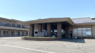 介護施設の玄関・車寄せ。広々とした駐車スペースと大きなガラス張りの入口